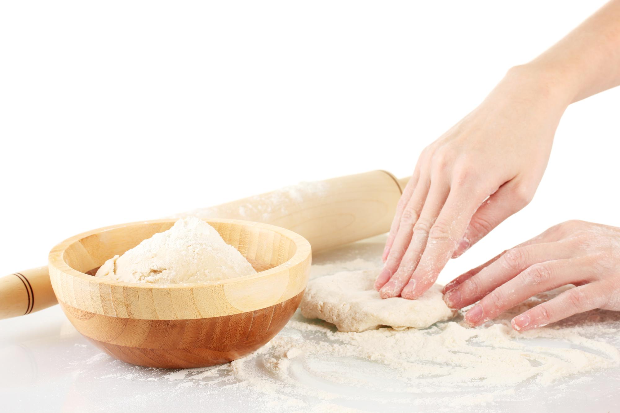 Close-up of hands kneading dough in natural light